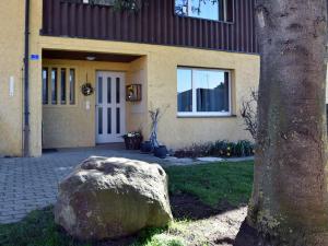 a rock in front of a house with a tree at Haslers Hof in Dinhard +21 photos