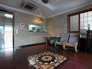 a lobby with two chairs and a table in a building at Monaco Hotel Jeju in Jeju