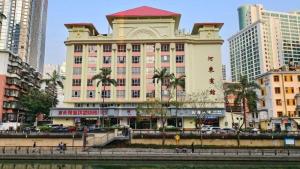 a large building with a red roof in a city at Hedong Hotel in Shenzhen