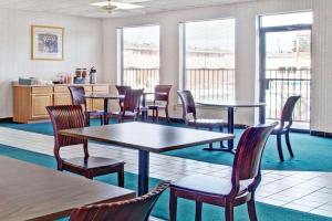 a dining room with tables and chairs and windows at Knights Inn South Houston TX in Houston