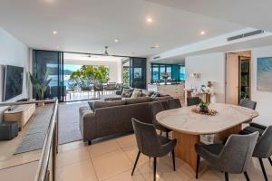 an open living room with a table and chairs at Edge 2 - Oceanfront Luxurious and Spacious 4 Bedroom Split Level Apartment with buggy and valet service in Hamilton Island