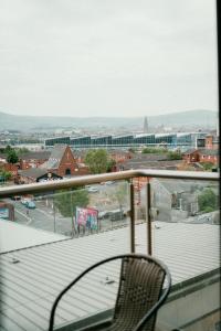 a chair sitting on a balcony overlooking a city at Urban Elegance: Luxury; Sleeps 6 in Belfast