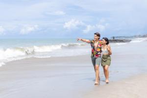 a man and a woman walking on the beach at Alam Canggu Kuta by ABM in Canggu