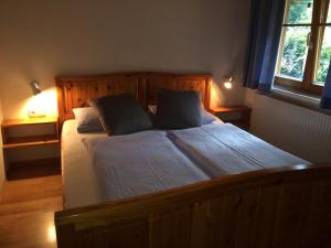 a bedroom with a large wooden bed with two pillows at Küferhof in Mellau