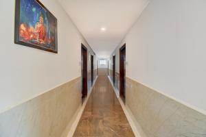 Super Townhouse Oak Sri Mahadeshwara Convention Centre Formerly Shri Aprameya Resort في Hārohalli: مدخل بجدران بيضاء ولوحة على الحائط