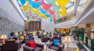 Un vestíbulo de hotel con sillas y un techo colorido. en Kunming Jinjiang Hotel, en Kunming