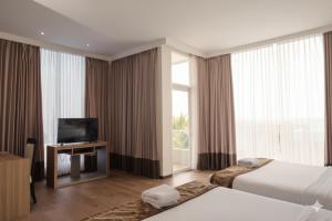 a hotel room with two beds and a television at D'Season Premiere Hotel in Kesembu