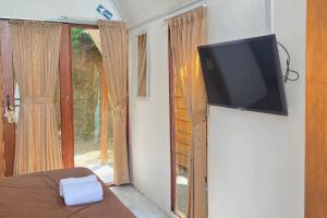 a bedroom with a flat screen tv on a wall at Mentari Ocean View Resort in Tamperan