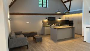 a kitchen with a counter and a couch in a room at Les 4 Fontaines in Osenbach