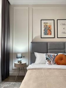 Un dormitorio con una cama y una mesa con una lámpara. en Экспо апарт 176, en Astana 9 fotos más