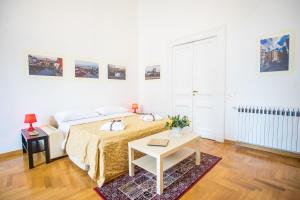 - une chambre blanche avec un lit et une table dans l'établissement Casa Napoletana - San Domenico, à Naples