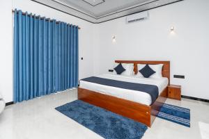 Schlafzimmer mit einem Bett mit blauen Vorhängen in der Unterkunft Arice Eco Villa and Restaurant Unawatuna in Galle