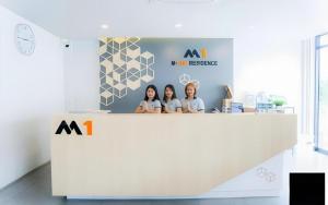 een groep van drie vrouwen die achter een balie staan bij M-one Residence in Ban Kohong