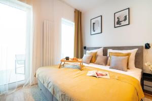 a bedroom with a large yellow bed with a table on it at apartino - free parking v okolí - in the neighbourhood, city view balcony, nespresso, netflix in Komárov