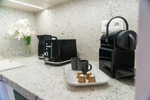 a kitchen counter with two coffee cups on a plate at apartino - free parking v okolí - in the neighbourhood, city view balcony, nespresso, netflix in Komárov +9 photos