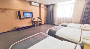 a hospital room with two beds and a flat screen tv at Thank Inn Plus Hotel Jiangyin University in Wuxi
