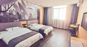 a hotel room with two beds and a painting on the wall at Thank Inn Plus Hotel Jiangyin University in Wuxi +118 photos