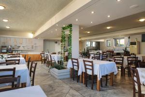 アギア・マリーナ・ネア・キドニアスにあるHotel Haris on the beachの白いテーブルと椅子のあるダイニングルーム