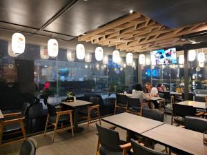 a restaurant with tables and chairs and people sitting at Neca Reiche in Hat Yai