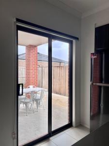 a sliding glass door leading to a patio with a table at Mahzan on Kilcunda - Ensuite 4 in Truganina