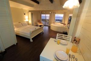 1 dormitorio con cama, bañera y mesa en נופי גמלא, en Ma'ale Gamla 17 fotos más