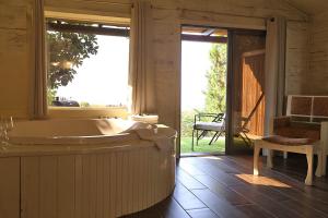 a large bathroom with a tub and a large window at נופי גמלא - 2 סוויטות מדהימות ונעימות לזוגות במעלה גמלא in Ma'ale Gamla