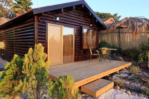 Cabaña con terraza de madera y mesa en נופי גמלא, en Ma'ale Gamla