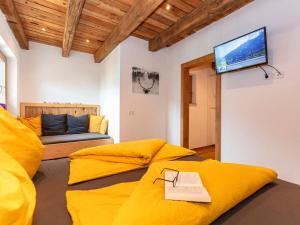 a living room with a yellow couch and a flat screen tv at Apartment Wiesbachhorn Zell am See-Kaprun in Kitzsteinhorn