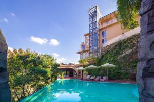 a swimming pool in front of a building at Zhangjiajie Shisuji Hotel (Zhangjiajie National Forest Park Sign Gate Branch) in Zhangjiajie