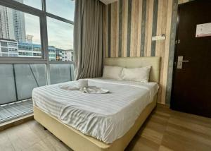 een bed in een kamer met een groot raam bij Swing & Pillows - KL City Kuchai Lama in Kuala Lumpur