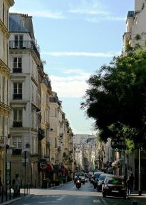 WS Opéra - Milan في باريس: شارع المدينة مع السيارات والدراجات النارية التي تسير في الشارع