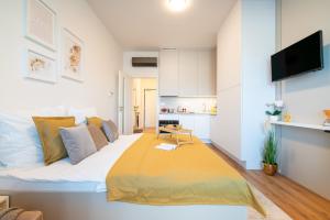 a bedroom with a large bed with a yellow blanket at apartino - FREE parking - Novostavba - Omezený přístup a stavební ruch - New Building - Limited Access and Construction noise in Komárov