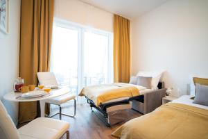 a room with two beds and a table and a window at apartino - FREE parking - Novostavba - Omezený přístup a stavební ruch - New Building - Limited Access and Construction noise in Komárov