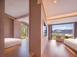 a bedroom with two beds and a large window at Zhangjiajie Shisuji Hotel (Zhangjiajie National Forest Park Sign Gate Branch) in Zhangjiajie +97 photos