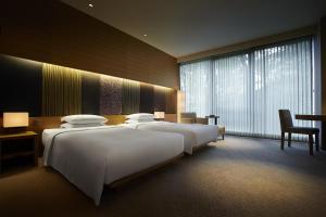a hotel room with two beds and a large window at Hyatt Regency Kyoto in Kyoto