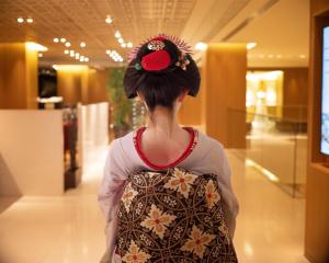 a woman wearing a kimono with a red flower in her hair at Hyatt Regency Kyoto in Kyoto +106 photos