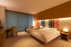 a hotel room with a large bed and a desk at Hyatt Regency Kyoto in Kyoto
