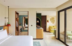 Un dormitorio con una cama y una sala de estar. en Kleo Seminyak, part of JdV by Hyatt, en Seminyak