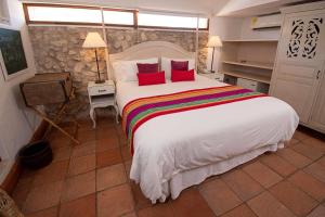 a bedroom with a large white bed with red pillows at Hotel Bantu by Faranda Boutique, a member of Radisson Individuals in Cartagena de Indias