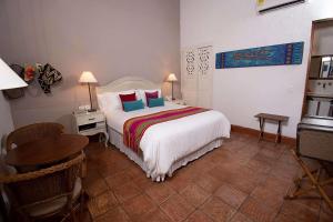 a hotel room with a bed and a table and a desk at Hotel Bantu by Faranda Boutique, a member of Radisson Individuals in Cartagena de Indias +104 photos