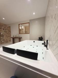una grande vasca da bagno bianca in una camera con di Cottage a Pontivy