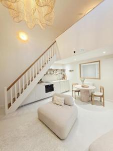 un soggiorno bianco con scala e divano di Cottage a Pontivy