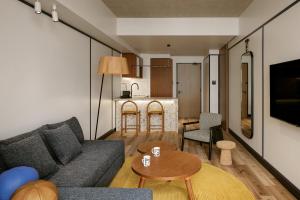 東京にあるCaption By Hyatt Kabutocho Tokyoのソファとテーブルのあるリビングルーム