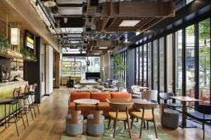 東京にあるCaption By Hyatt Kabutocho Tokyoのテーブルと椅子と大きな窓のあるレストラン