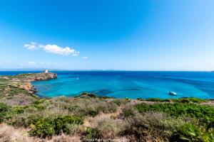 ein Blick auf das Meer mit einem Leuchtturm in der Ferne in der Unterkunft Ferienhaus für 6 Personen ca 200 m in Sant'Antìoco, Sardinien Sulcis Iglesiente in Crisionis