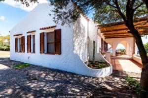 ein weißes Haus mit einem Baum davor in der Unterkunft Ferienhaus für 6 Personen ca 200 m in Sant'Antìoco, Sardinien Sulcis Iglesiente in Crisionis + 32 Fotos