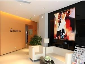 a living room with a large tv on a wall at Jinjiang Inn Weihai High Speed Qingdao South Road in Weihai