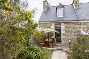 een stenen huis met een tafel en stoelen bij La fringante in Pleubian +17 foto's