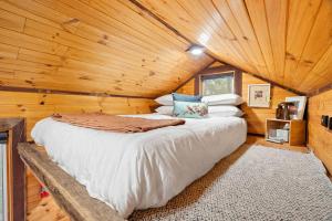 ein Schlafzimmer mit einem Bett in einer Blockhütte in der Unterkunft Hillsview Cottage by Tiny Away in Taradale
