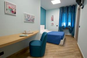 1 dormitorio con 1 cama azul y 1 silla azul en Relais Piazza Garibaldi, en Terracina